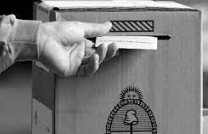 Mano depositando voto en una urna